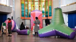 Das Bild zeigt einige der Luftkissen-Objekte und Personen, die sich diese Objekte anschauen